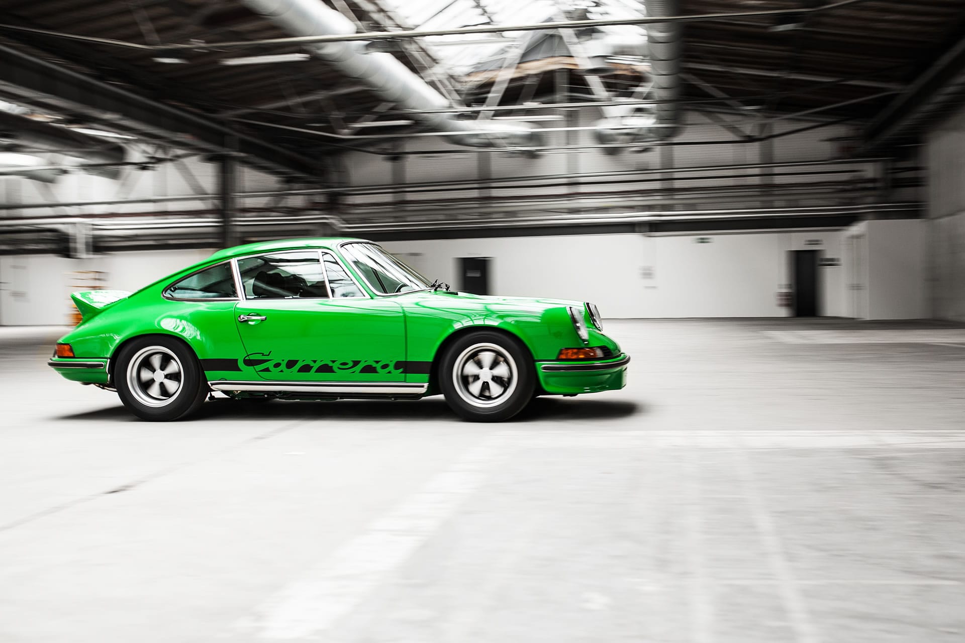 Carrera RS 2.7 in Viperngrün, rollende Seitenansicht in der Halle
