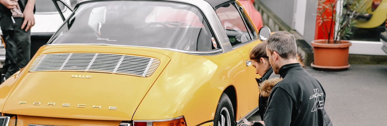 Kunden und Team an einem Targa vor der Werkstatt