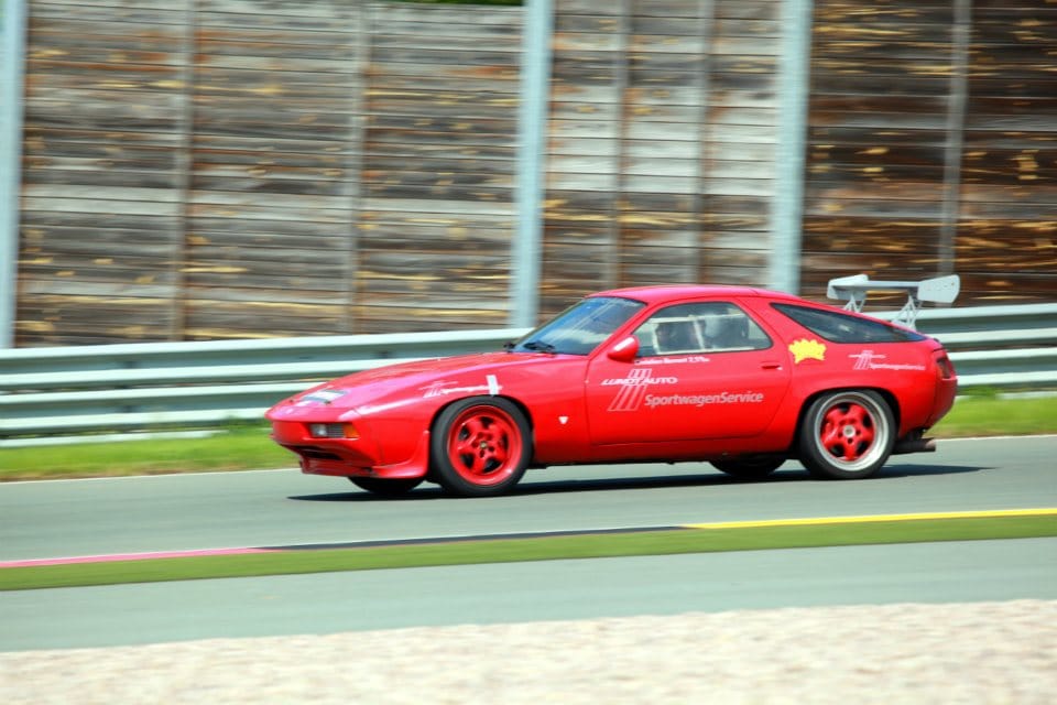 Roter Porsche 928 mit Sportwagen-Service-Beschriftung auf der Strecke beim Fahrtraining