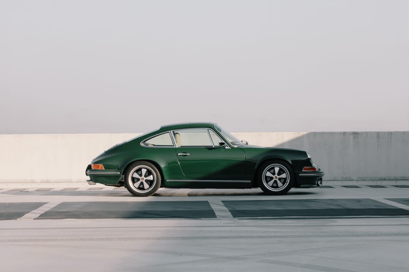 The Green Machine — irischgrünes 964-Backdate im Seitenprofil auf einem Parkdeck